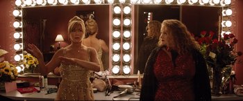 Movie still from “Dumplin'” (2018), directed by Anne Fletcher – Two women in front of a mirror in a dressing room; Medium shot, High angle