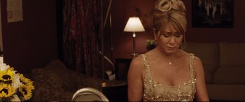 Movie still from “Dumplin'” (2018), directed by Anne Fletcher – A woman sitting in a chair wearing a gold dress; Close Up shot, Over the shoulder angle