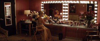 Movie still from “Dumplin'” (2018), directed by Anne Fletcher – A woman sitting in front of a mirror in a dressing room; Wide shot, High angle