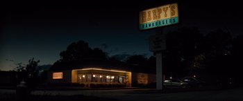 Movie still from “Dumplin'” (2018), directed by Anne Fletcher – A night time view of a hamburger restaurant; Extreme Wide shot, Low angle