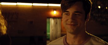 Movie still from “Dumplin'” (2018), directed by Anne Fletcher – A person smiling for the camera; Close Up shot, Over the shoulder angle