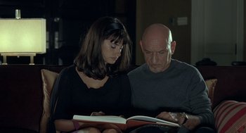 Movie still from “Elegy” (2008), directed by Isabel Coixet – A man and a woman are reading a book together; Medium shot, Over the shoulder angle