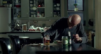 Movie still from “Elegy” (2008), directed by Isabel Coixet – A man sitting at a table with a drink in front of him; Medium shot, Over the shoulder angle