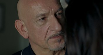 Movie still from “Elegy” (2008), directed by Isabel Coixet – An older man with a shaved head looking at the camera; Close Up shot, Over the shoulder angle