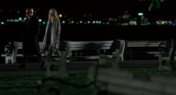 Movie still from “Elegy” (2008), directed by Isabel Coixet – A woman is walking on the grass near a bench; Wide shot, High angle