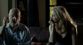 Movie still from “Elegy” (2008), directed by Isabel Coixet – A man and a woman sitting on a couch looking at each other; Medium shot, Over the shoulder angle