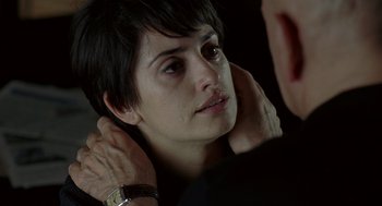 Movie still from “Elegy” (2008), directed by Isabel Coixet – A woman with short black hair is looking at her reflection in a mirror; Close Up shot, Over the shoulder angle