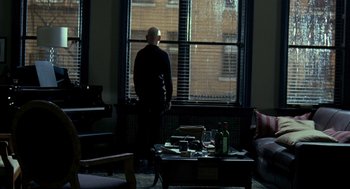 Movie still from “Elegy” (2008), directed by Isabel Coixet – A man standing in front of a large window; Wide shot, High angle