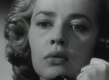 Movie still from “Elevator to the Gallows” (1958), directed by Louis Malle – A woman's face while holding a cell phone to her ear; Close Up shot, Low angle