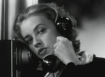 Movie still from “Elevator to the Gallows” (1958), directed by Louis Malle – A black and white photo of a woman talking on a phone; Close Up shot, Low angle