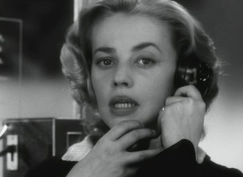 Movie still from “Elevator to the Gallows” (1958), directed by Louis Malle – A black and white photo of a woman talking on a phone; Close Up shot, Low angle