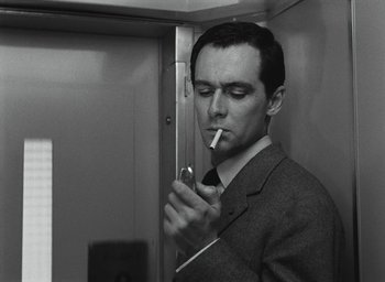 Movie still from “Elevator to the Gallows” (1958), directed by Louis Malle – A black and white photo of a man smoking a cigarette; Close Up shot, Low angle