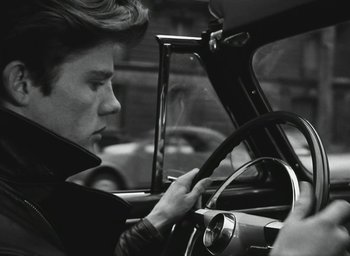 Movie still from “Elevator to the Gallows” (1958), directed by Louis Malle – A man sitting in the driver's seat of a car; Close Up shot, Over the shoulder angle