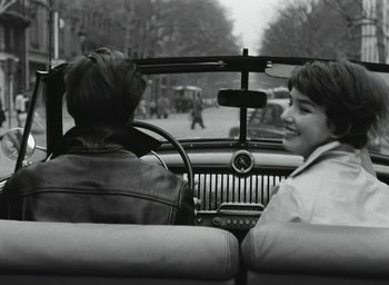 Movie still from “Elevator to the Gallows” (1958), directed by Louis Malle – Two young boys in the backseat of a car; Medium shot, Over the shoulder angle