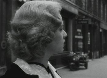 Movie still from “Elevator to the Gallows” (1958), directed by Louis Malle – A black and white photo of a woman in the street; Close Up shot, Over the shoulder angle