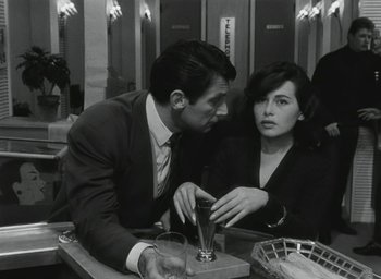 Movie still from “Elevator to the Gallows” (1958), directed by Louis Malle – A black and white photo of a man and a woman at a bar; Medium shot, Over the shoulder angle