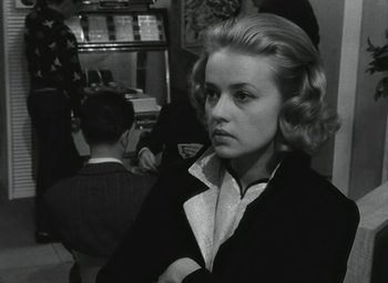 Movie still from “Elevator to the Gallows” (1958), directed by Louis Malle – A black and white photo of a woman in a suit; Close Up shot, Over the shoulder angle