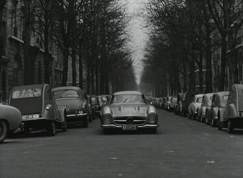Movie still from “Elevator to the Gallows” (1958), directed by Louis Malle – An old photo of cars parked on the side of the street; Wide shot, High angle