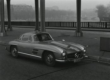 Movie still from “Elevator to the Gallows” (1958), directed by Louis Malle – An old car parked on the side of the road; Wide shot, High angle