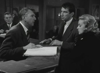 Movie still from “Elevator to the Gallows” (1958), directed by Louis Malle – A group of people sitting around a table; Medium shot, Low angle