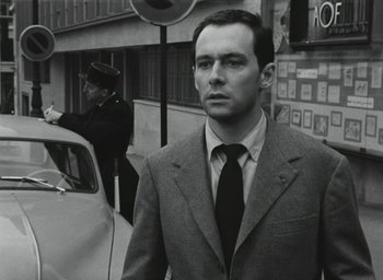 Movie still from “Elevator to the Gallows” (1958), directed by Louis Malle – Black and white photograph of a man wearing a suit and tie; Close Up shot, Over the shoulder angle