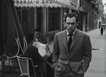 Movie still from “Elevator to the Gallows” (1958), directed by Louis Malle – A black and white photo of a man in a suit and tie; Medium shot, Low angle