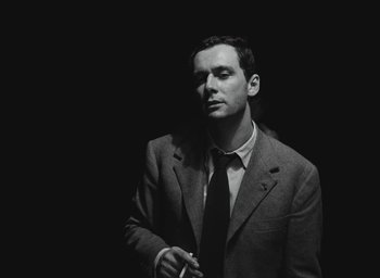 Movie still from “Elevator to the Gallows” (1958), directed by Louis Malle – Black and white photograph of a man wearing a suit and tie; Close Up shot, Low angle