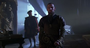 Movie still from “Elizabeth” (1998), directed by Shekhar Kapur – A man in a medieval outfit standing next to another man in medieval clothing; Medium shot, Low angle