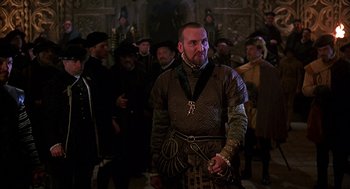 Movie still from “Elizabeth” (1998), directed by Shekhar Kapur – A group of men in medieval garb standing in a crowd; Medium shot, Over the shoulder angle