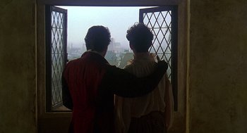 Movie still from “Elizabeth” (1998), directed by Shekhar Kapur – A man and a woman standing next to each other looking out of a window; Medium shot, Over the shoulder angle