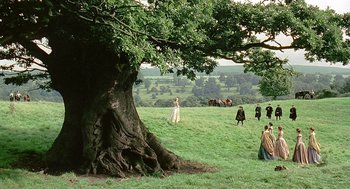 Movie still from “Elizabeth” (1998), directed by Shekhar Kapur – A group of people standing under a large tree in a field; Extreme Wide shot, High angle
