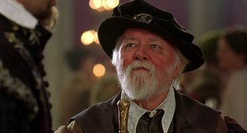 Movie still from “Elizabeth” (1998), directed by Shekhar Kapur – An old man with a beard wearing a hat; Close Up shot, Over the shoulder angle