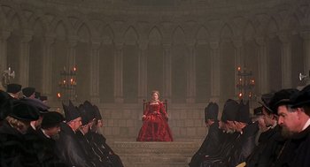 Movie still from “Elizabeth” (1998), directed by Shekhar Kapur – A woman in a red dress sitting on a throne; Wide shot, High angle