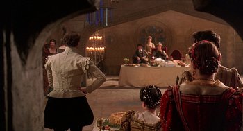 Movie still from “Elizabeth” (1998), directed by Shekhar Kapur – A group of people sitting around a table; Wide shot, Over the shoulder angle