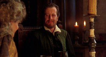 Movie still from “Elizabeth” (1998), directed by Shekhar Kapur – A person sitting in a chair near a candle; Close Up shot, Over the shoulder angle