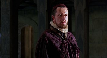 Movie still from “Elizabeth” (1998), directed by Shekhar Kapur – A person wearing a robe and a hat; Close Up shot, Over the shoulder angle