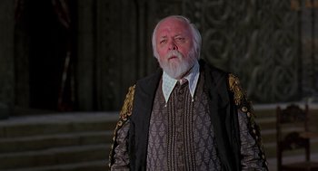 Movie still from “Elizabeth” (1998), directed by Shekhar Kapur – An old man with a beard and a mustache wearing a suit; Medium shot, Low angle