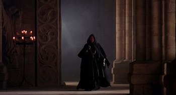 Movie still from “Elizabeth” (1998), directed by Shekhar Kapur – A man in a black robe and a black cape; Wide shot, Low angle