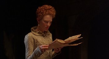 Movie still from “Elizabeth” (1998), directed by Shekhar Kapur – A woman with red curly hair reading a piece of paper; Close Up shot, Low angle