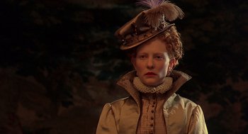 Movie still from “Elizabeth” (1998), directed by Shekhar Kapur – A woman wearing a hat with feathers on it; Close Up shot, Low angle