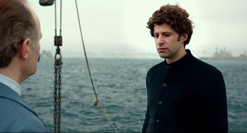 A man standing on the deck of a boat in the water