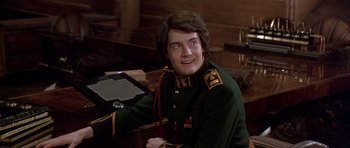 Movie still from “Dune” (1984), directed by David Lynch – A man in a uniform sitting at a desk; Close Up shot, Over the shoulder angle