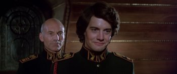 Movie still from “Dune” (1984), directed by David Lynch – A man in a military uniform and a bald man in a military uniform; Close Up shot, Over the shoulder angle