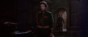 Movie still from “Dune” (1984), directed by David Lynch – A man in a military uniform standing next to another man in a uniform; Medium shot, Low angle