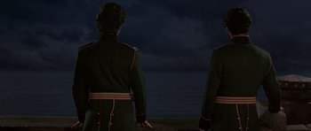 Movie still from “Dune” (1984), directed by David Lynch – Two men in military uniforms looking out at the ocean; Medium shot, Low angle