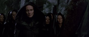 Movie still from “Dune” (1984), directed by David Lynch – A group of people in black robes and hoods; Medium shot, Low angle
