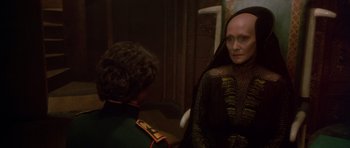 Movie still from “Dune” (1984), directed by David Lynch – A woman in a black dress and a man in a green suit; Close Up shot, Over the shoulder angle