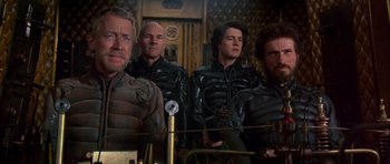 Movie still from “Dune” (1984), directed by David Lynch – A group of men in black leather jackets; Medium shot, Over the shoulder angle