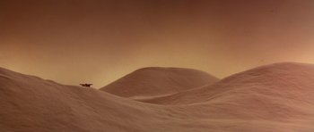 Movie still from “Dune” (1984), directed by David Lynch – A person is standing in the sand dunes; Extreme Wide shot, Low angle
