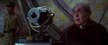 Movie still from “Dune” (1984), directed by David Lynch – An older man sitting in front of an old fashioned radio; Close Up shot, Low angle